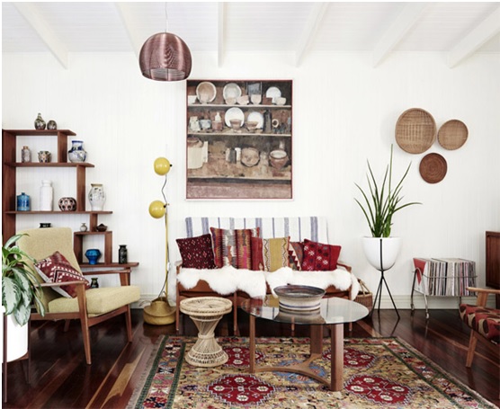 Salon de style gypset : tapis berbère, coussins colorés, assiettes et paniers tressés au mur
