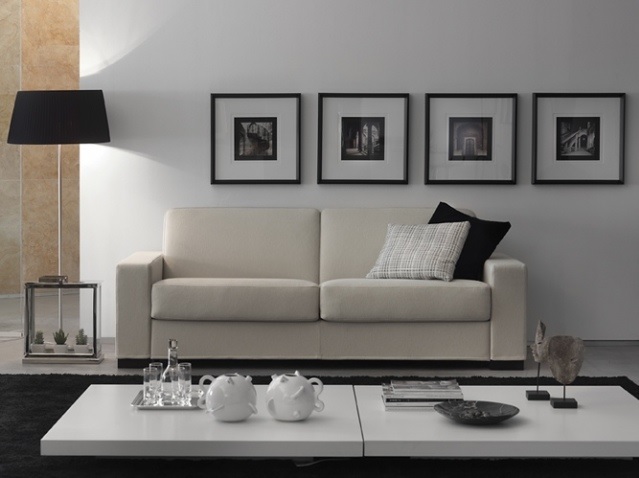 Salon contemporain : canapé blanc, cadres noirs alignés et lampadaire noir