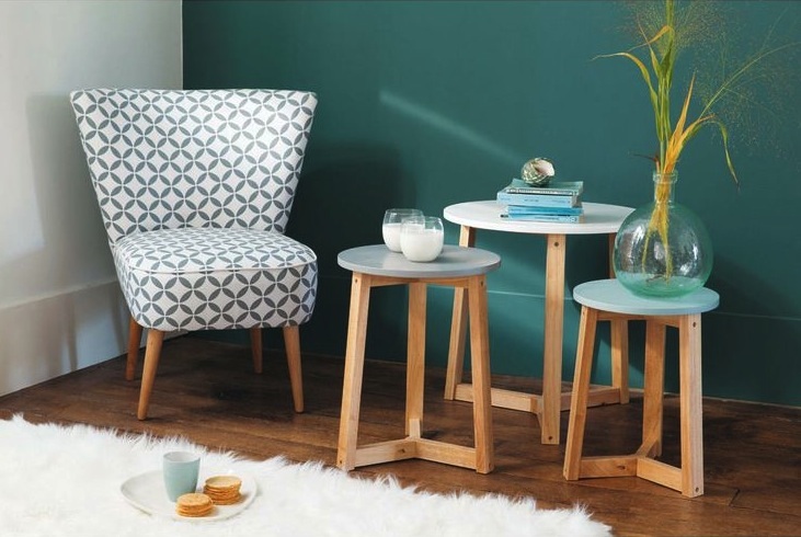Décoration scandinave : fauteuil à motifs graphiques, tables gigognes en bois clair et tapis blanc