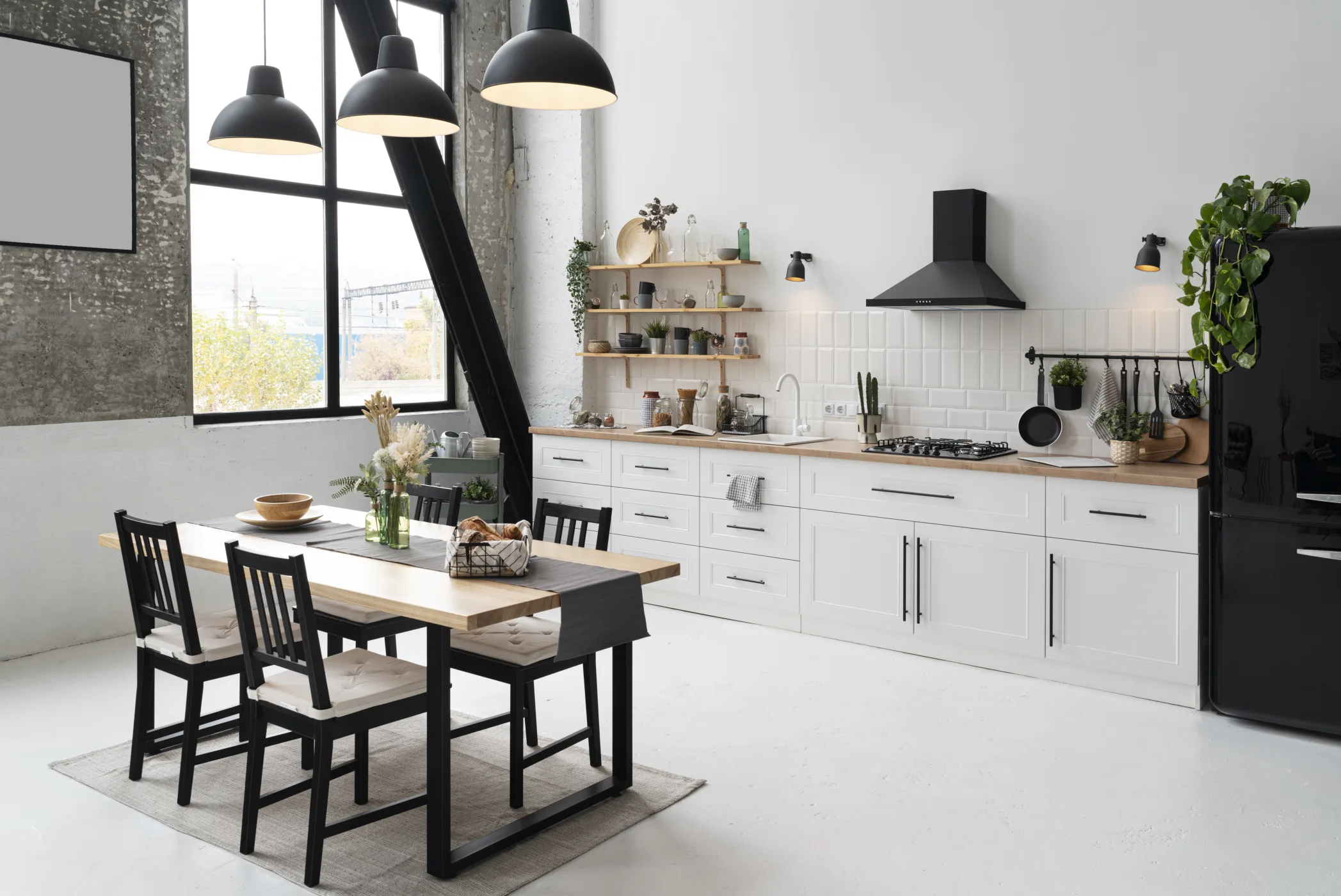 Cuisine sur mesure en Seine-et-Marne, plan de travail en bois, étagères ouvertes et table à piètement noir